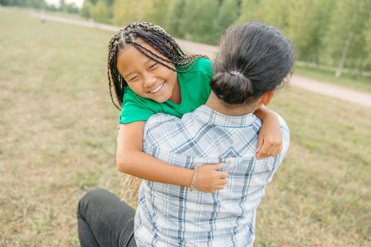 Parent hugging child outdoors